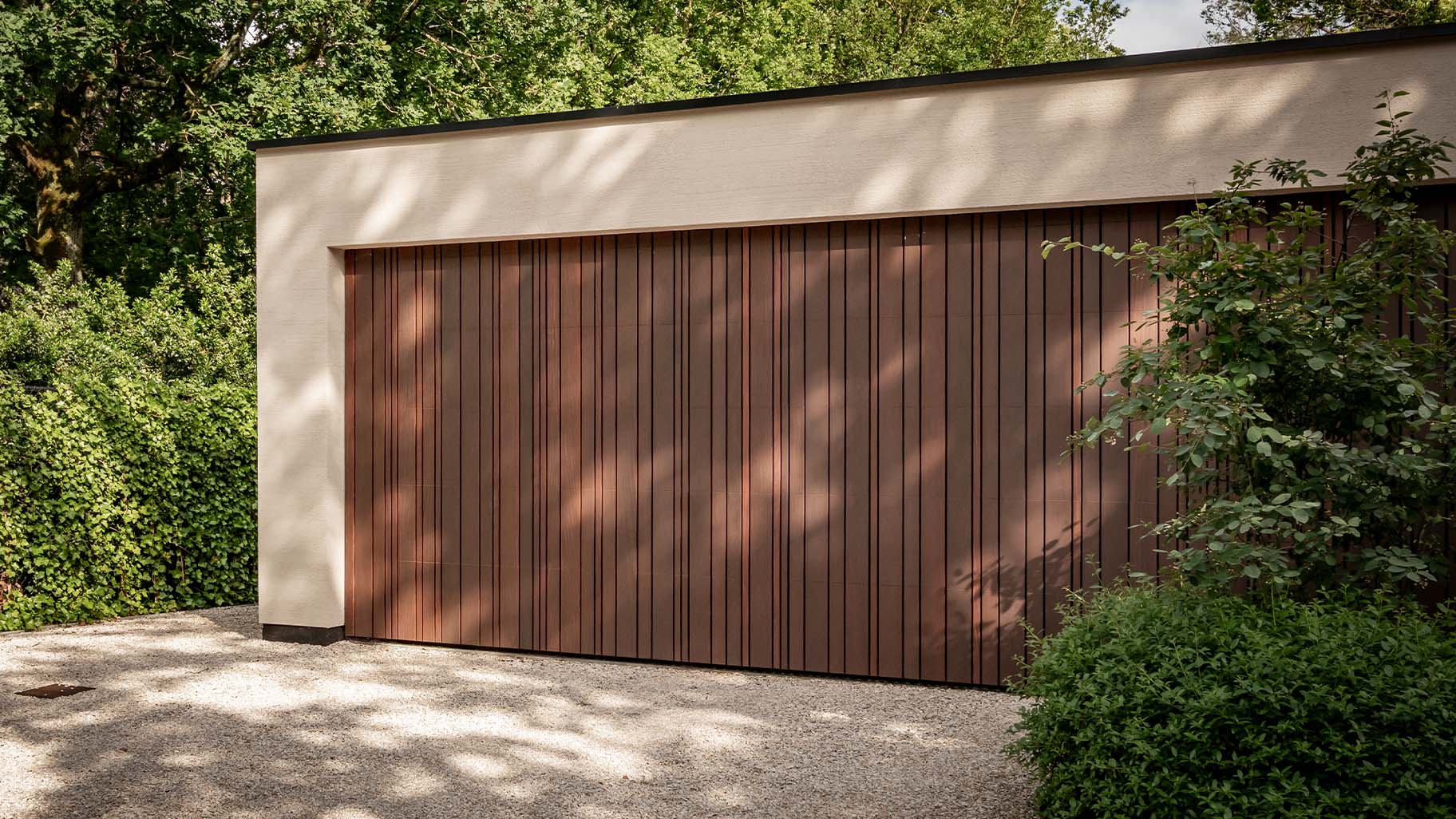 Garage door with cladding in a varied pattern, discreetly integrated into the façade