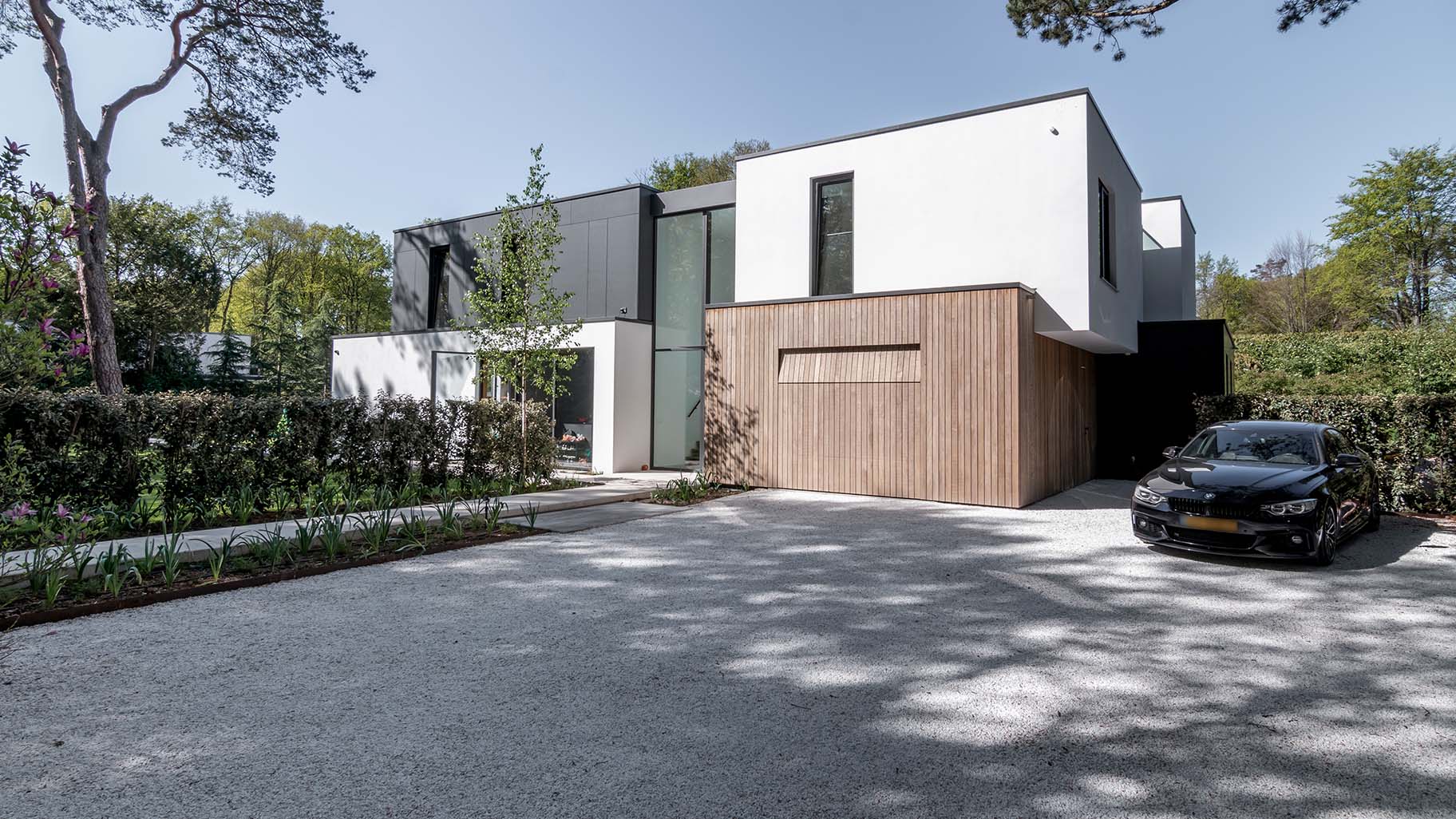 Wooden garage door that blends into the facade of a modern villa —Different Doors