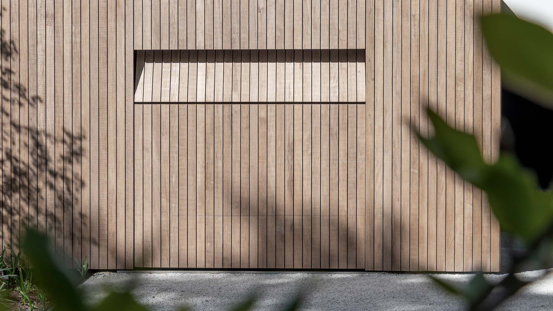 Holz-Garagentor, das mit der Fassade einer modernen Villa verschmilzt | Different Doors