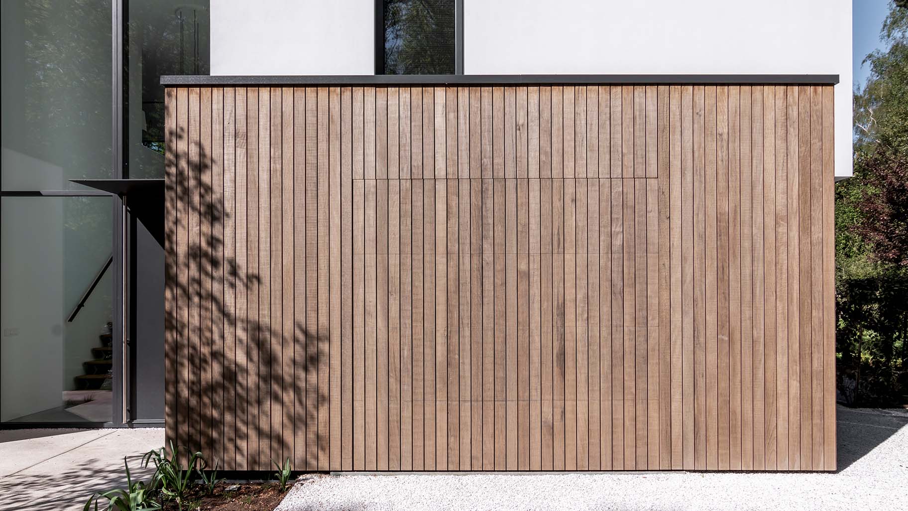 Holz-Garagentor, das mit der Fassade einer modernen Villa verschmilzt | Different Doors
