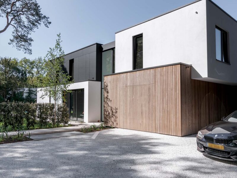 Wooden garage door that blends into the facade of a modern villa — Different Doors