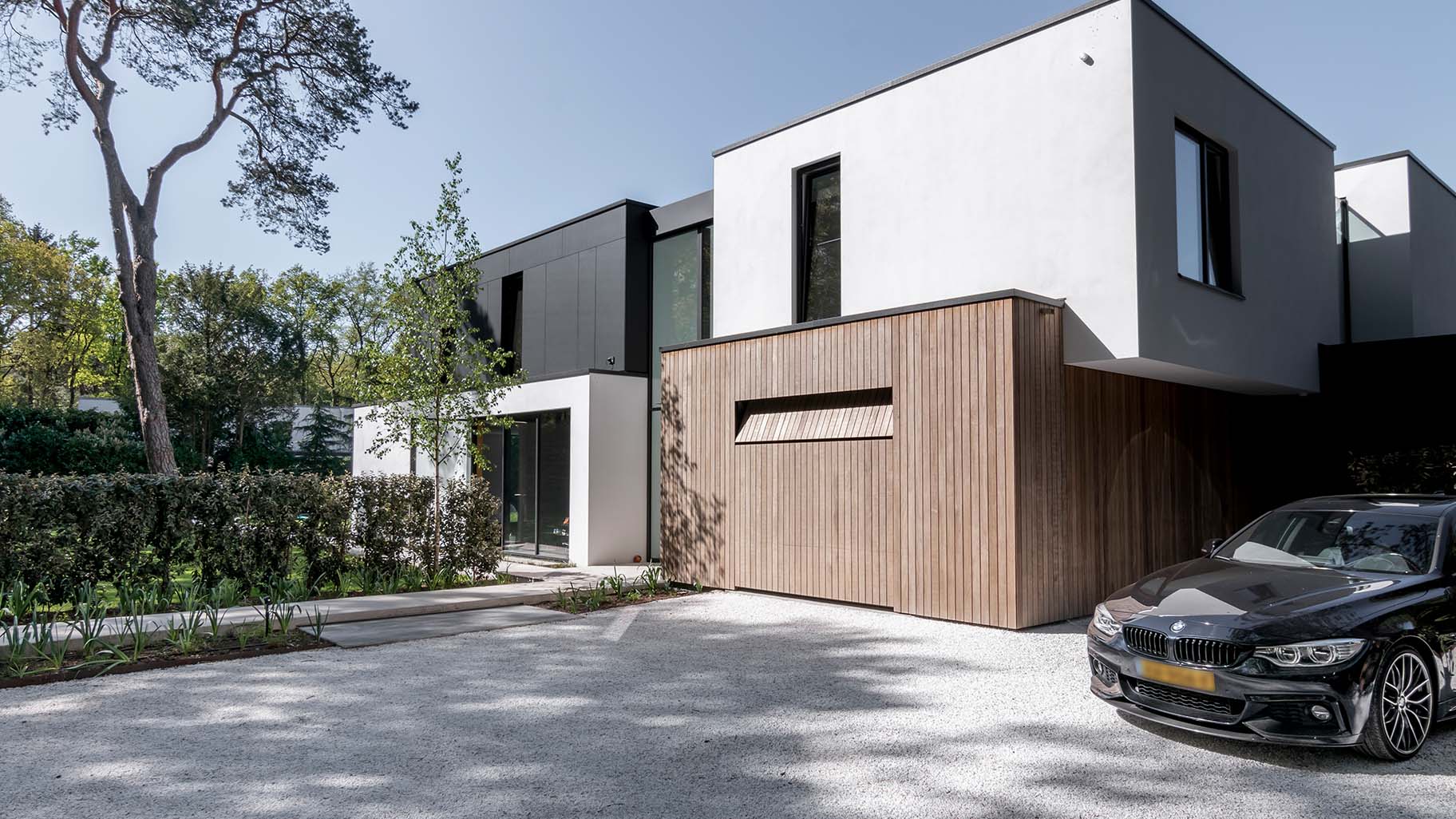 Holz-Garagentor, das mit der Fassade einer modernen Villa verschmilzt | Different Doors