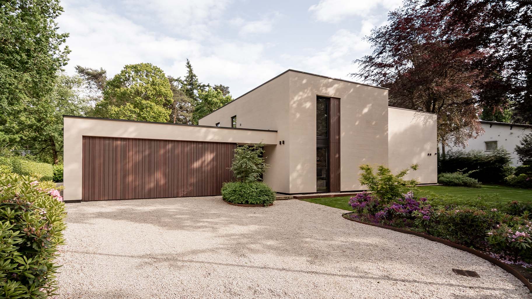 Garage door with cladding in a varied pattern, discreetly integrated into the façade