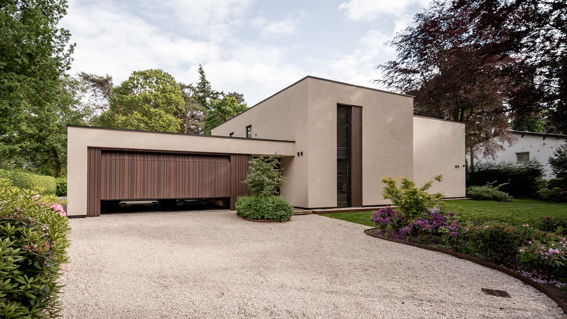 Garage door with cladding in a varied pattern, discreetly integrated into the façade