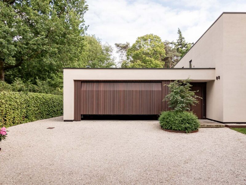 Garage door with cladding in a varied pattern, discreetly integrated into the façade