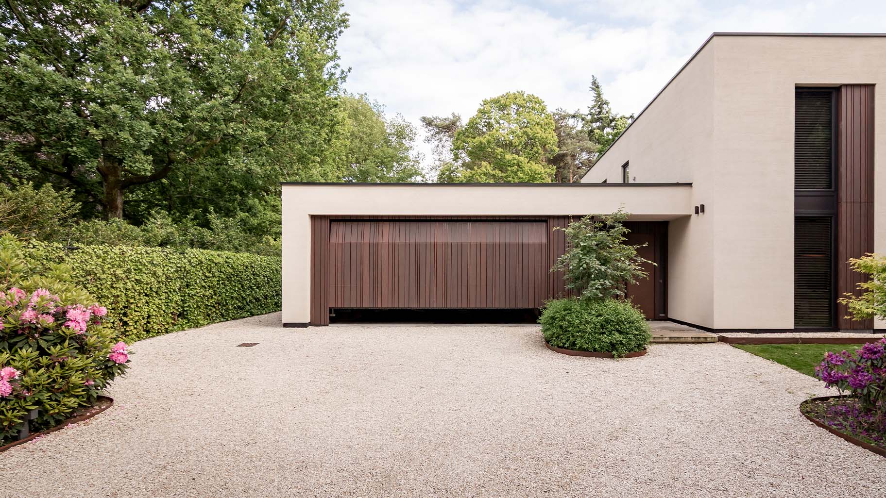 Garage door with cladding in a varied pattern, discreetly integrated into the façade