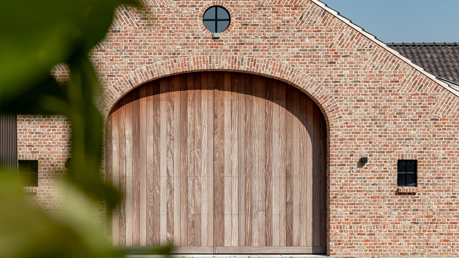 Afrormosia-Holz-Sektionaltore im klassischen Stil für eine Rundbogenfassade