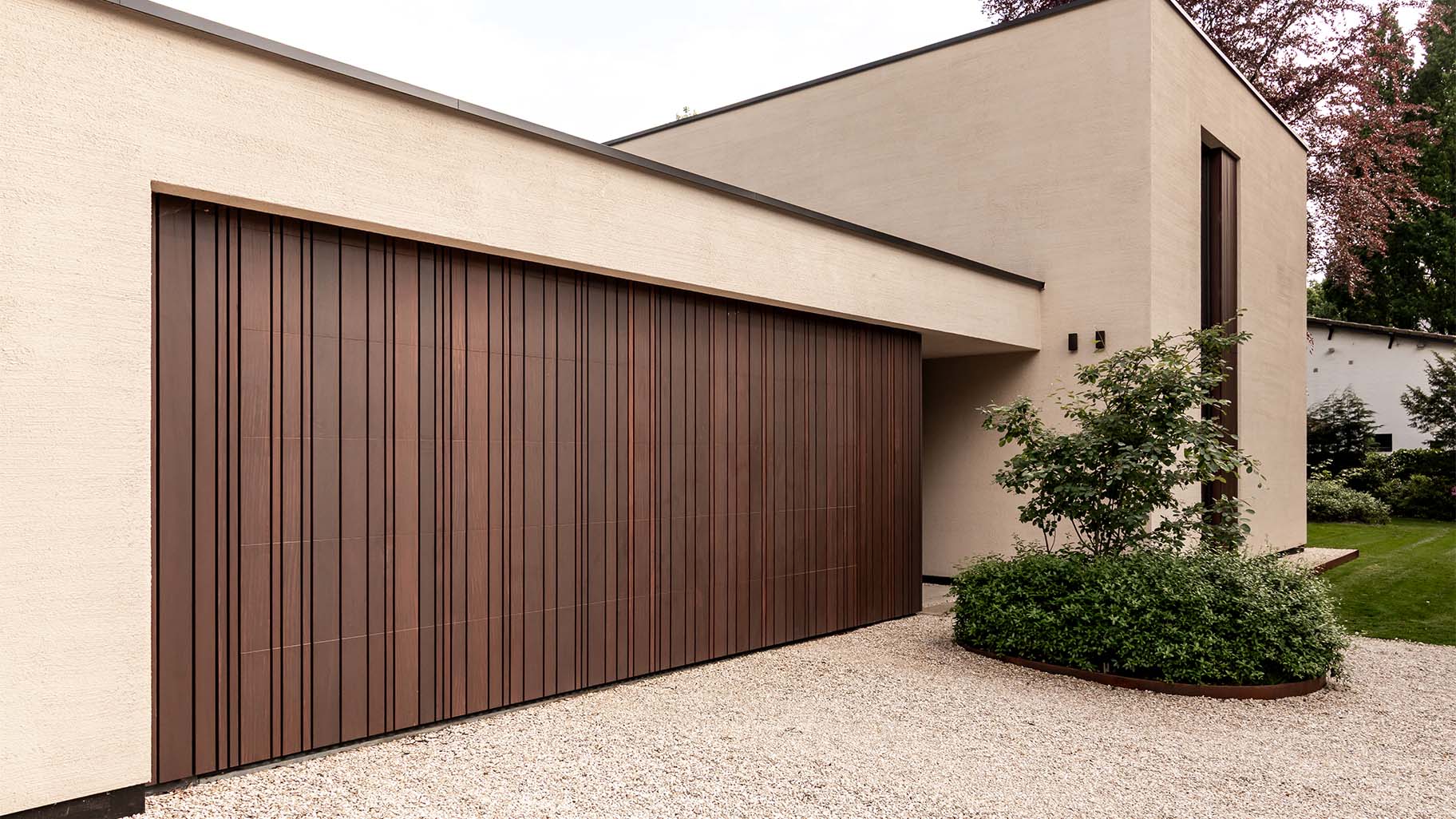 Garagentor mit variierenden Holzleisten, dezent in die Fassade integriert