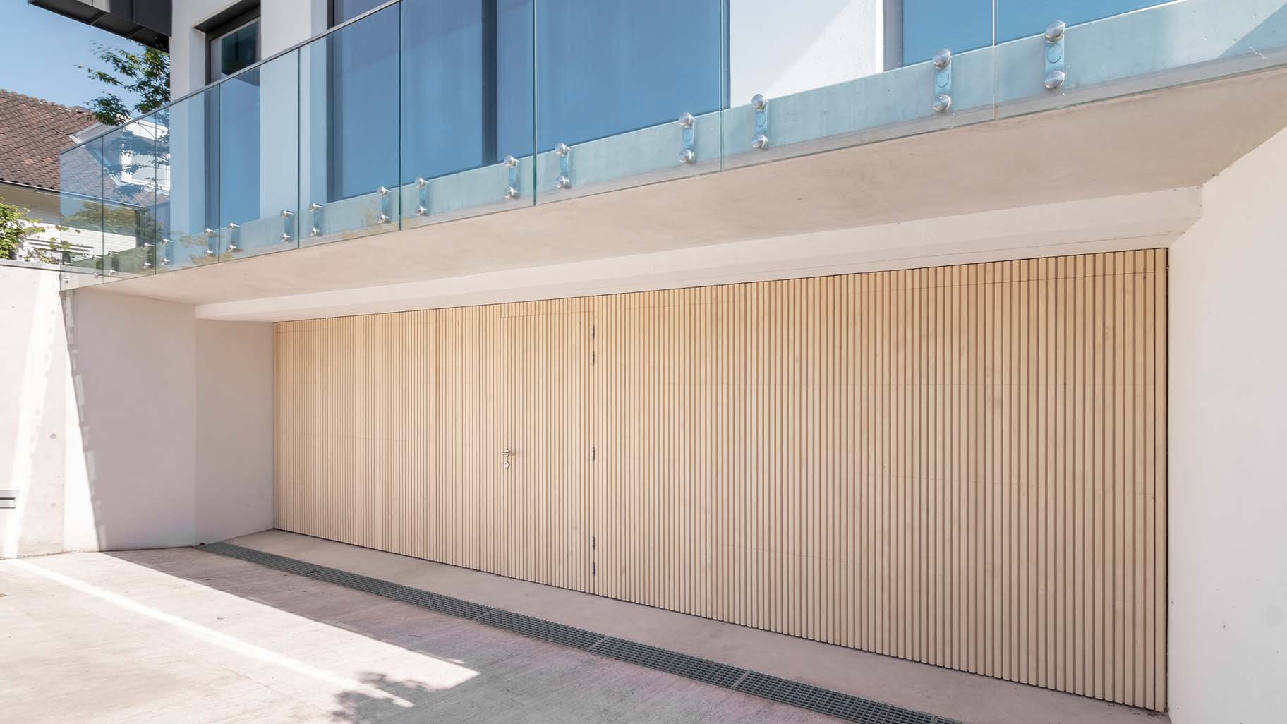 Accoya-Sektionaltore bündig in die Fassade integriert