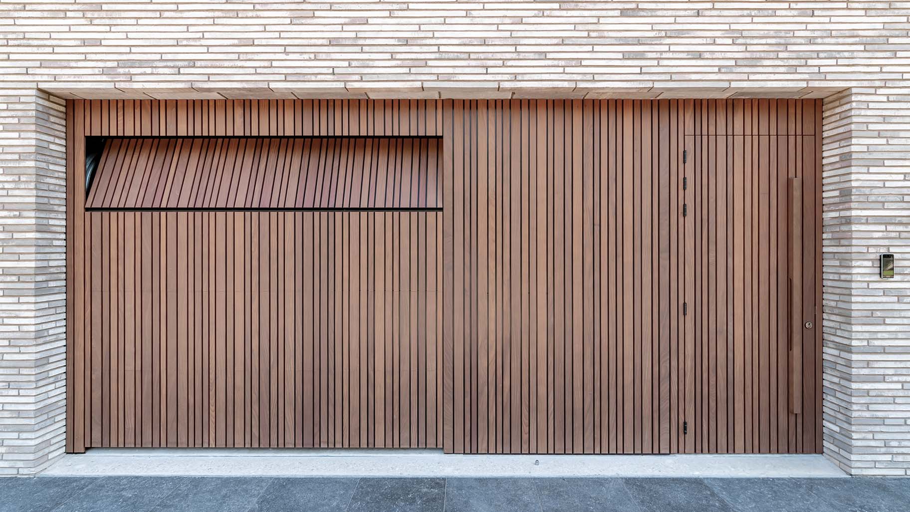 Invisible sectional garage door flush with facade - made from afrormosia