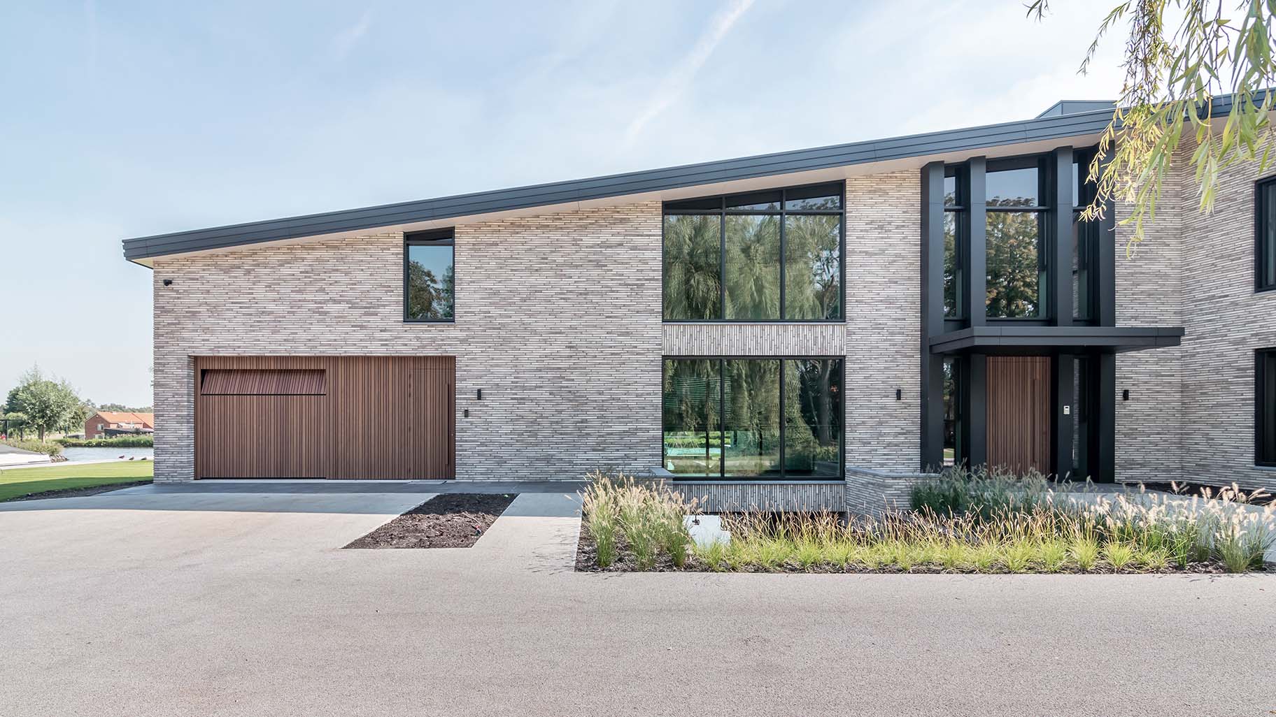 Invisible sectional garage door flush with facade - made from afrormosia