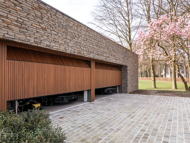 Two wooden garage doors hidden in the facade